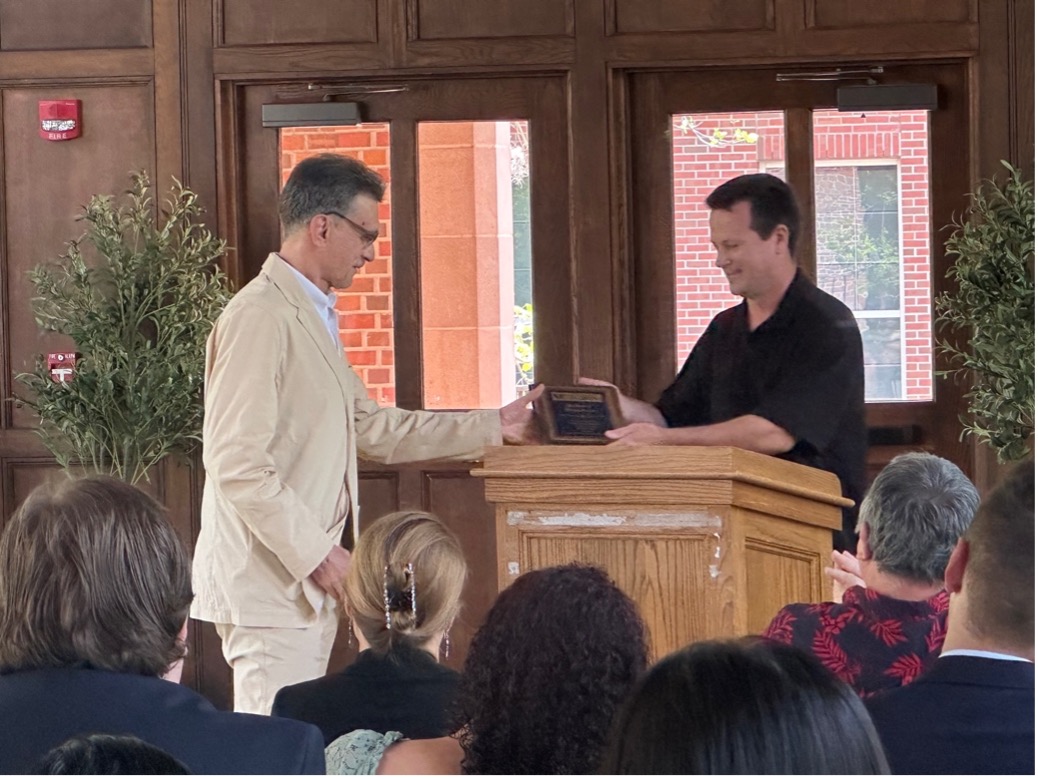 Man presenting a plaque to another man